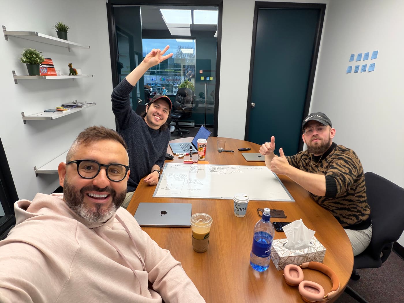 Tom with two Setsail team members around a whiteboard meeting table