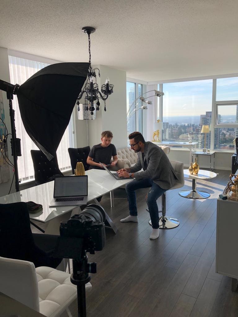Tom working with a colleague in a Vancouver apartment, mountain view behind